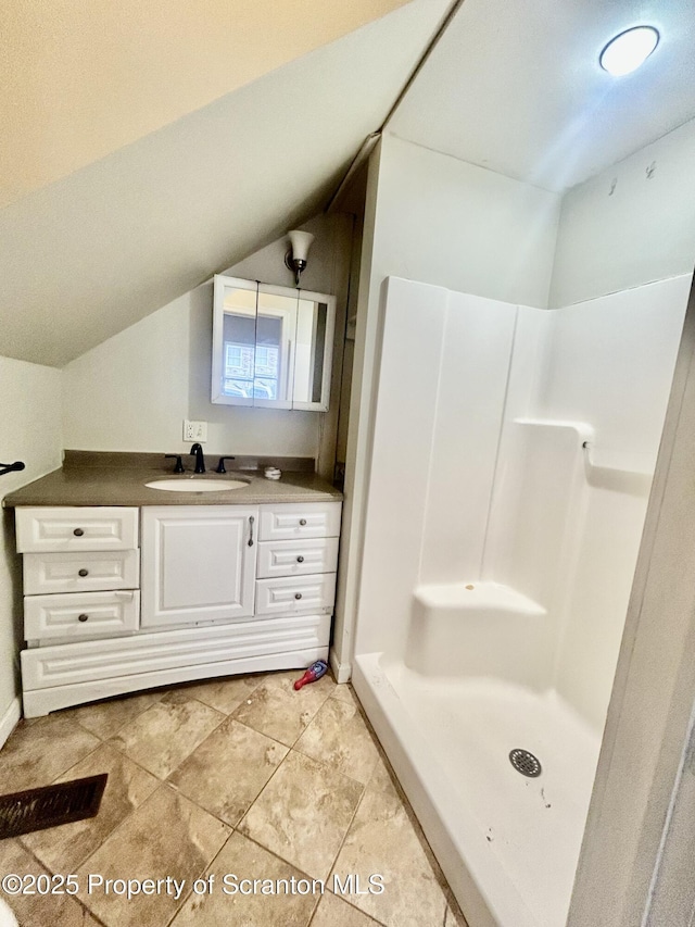 full bathroom featuring lofted ceiling, walk in shower, and vanity