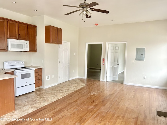 kitchen with white appliances, electric panel, light wood-style floors, and brown cabinets