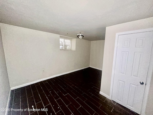 below grade area featuring baseboards and dark wood-type flooring