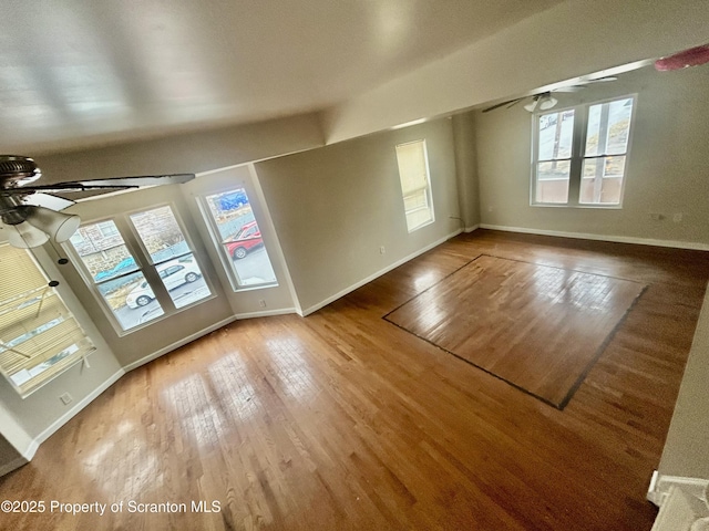 interior space with wood finished floors, baseboards, and ceiling fan