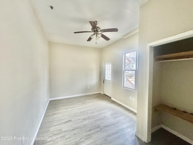 unfurnished bedroom with ceiling fan, baseboards, and wood finished floors