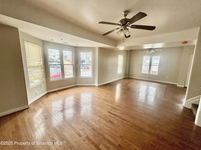 unfurnished living room with baseboards and wood finished floors