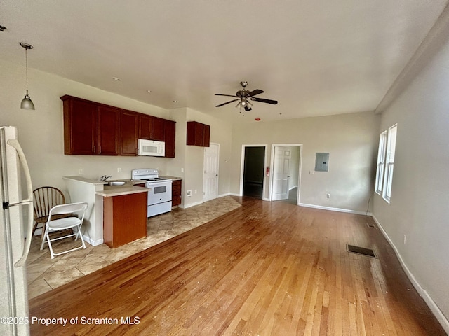 kitchen featuring visible vents, electric panel, white appliances, light wood-style floors, and light countertops