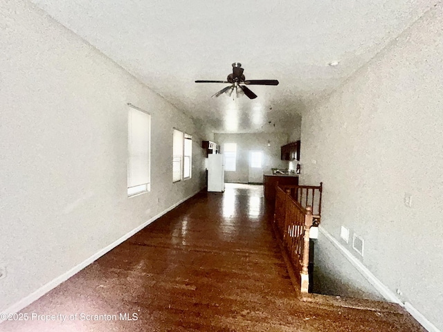 interior space with an upstairs landing, baseboards, and wood finished floors