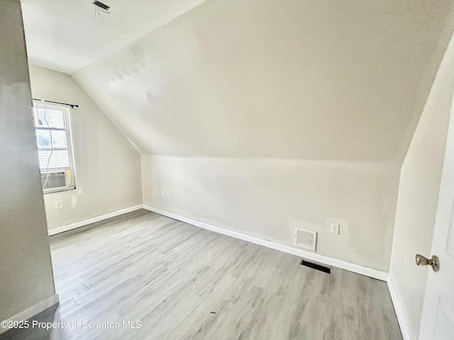 bonus room with visible vents, baseboards, lofted ceiling, cooling unit, and wood finished floors