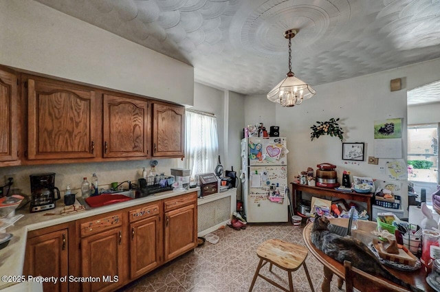 219 N Sumner Ave, Scranton, PA 18504 - kitchen with freestanding refrigerator, brown cabinets, light countertops, and pendant lighting