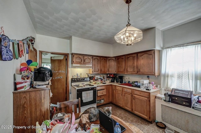 219 N Sumner Ave, Scranton, PA 18504 - kitchen with electric range oven, under cabinet range hood, a chandelier, light countertops, and pendant lighting