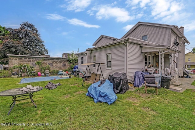 219 N Sumner Ave, Scranton, PA 18504 - back of house with a patio area, a yard, and a chimney