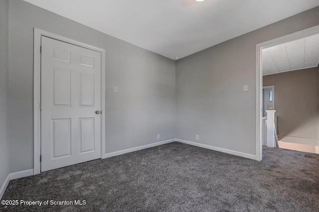 carpeted spare room featuring baseboards