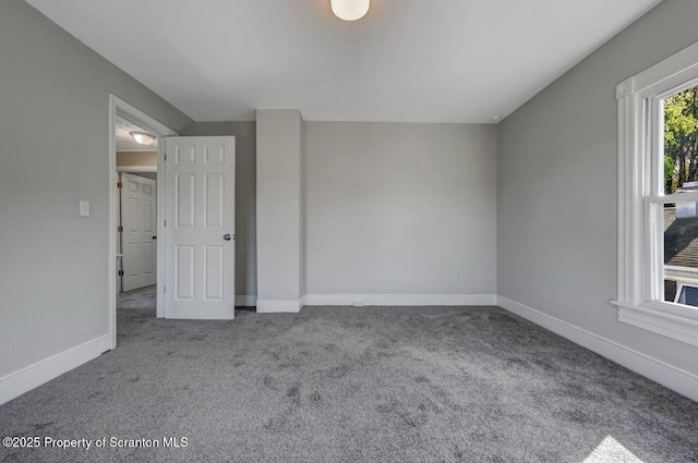 spare room with baseboards and carpet flooring