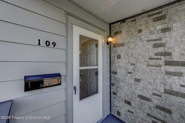 entrance to property featuring stone siding