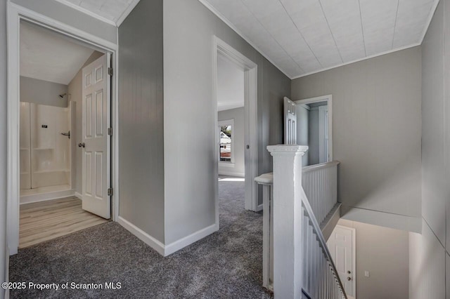 corridor with baseboards, carpet flooring, an upstairs landing, and ornamental molding