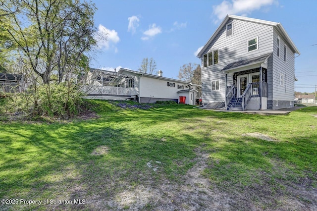rear view of property with a lawn