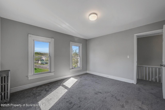 empty room featuring carpet floors and baseboards