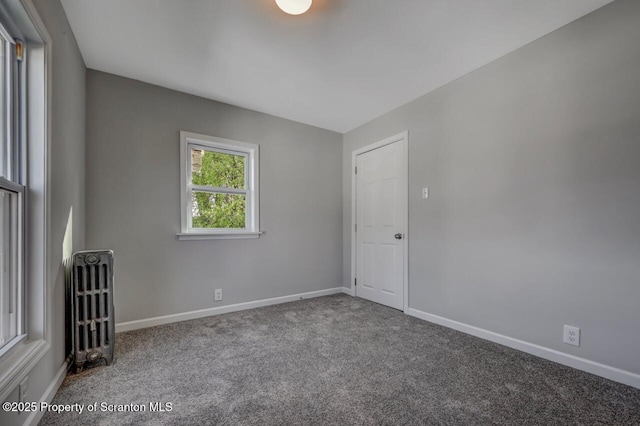 carpeted empty room featuring baseboards