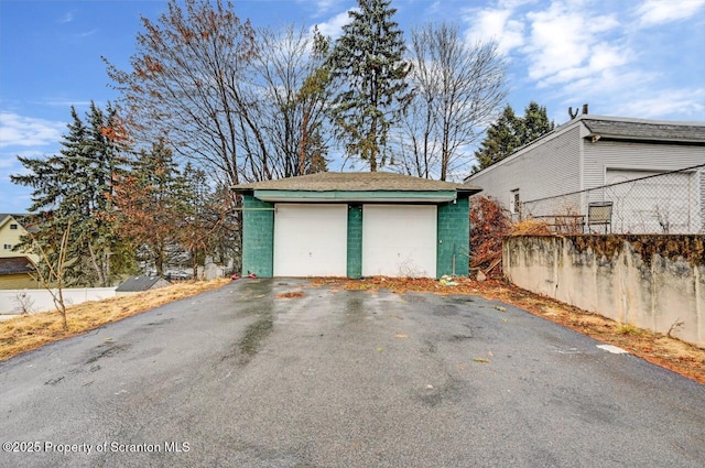 detached garage featuring fence