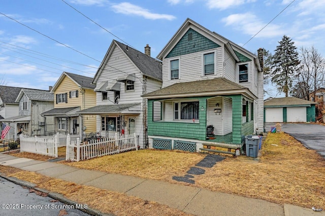 view of front of property with an outbuilding, roof with shingles, a porch, and a fenced front yard