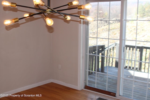 interior space with wood-type flooring and a chandelier