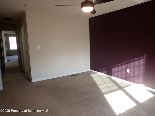 empty room with carpet floors and ceiling fan