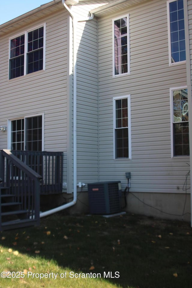 rear view of house featuring central AC and a deck