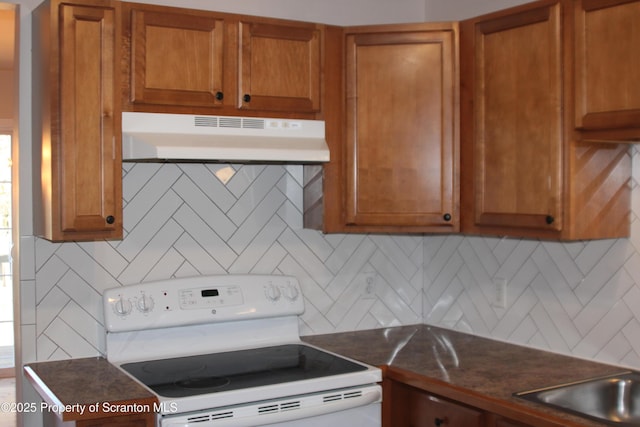 kitchen with tasteful backsplash and white range with electric stovetop