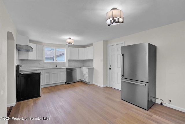 kitchen with white cabinetry, decorative backsplash, sink, and appliances with stainless steel finishes