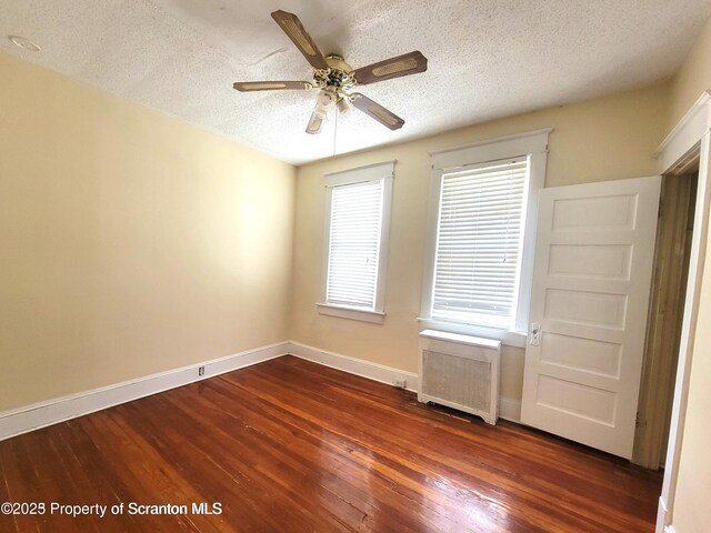 1518 Vine St, Scranton, PA 18510 - empty room with radiator heating unit, dark wood-type flooring, baseboards, a textured ceiling, and a ceiling fan