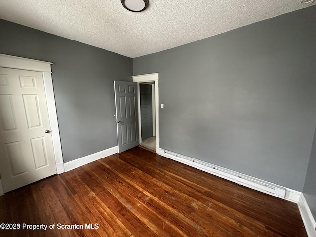 1518 Vine St, Scranton, PA 18510 - unfurnished bedroom with baseboards, a textured ceiling, wood finished floors, and baseboard heating