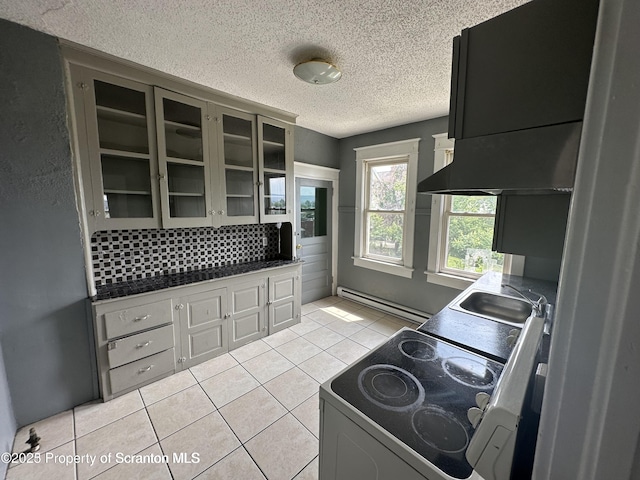 1518 Vine St, Scranton, PA 18510 - kitchen featuring electric range oven, a baseboard heating unit, light tile patterned floors, a textured ceiling, and glass insert cabinets