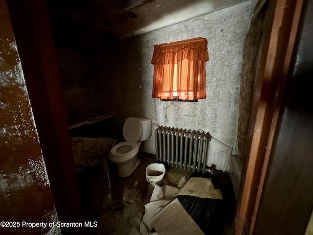 bathroom featuring radiator and toilet