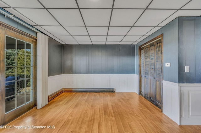 unfurnished room with light hardwood / wood-style floors and a drop ceiling