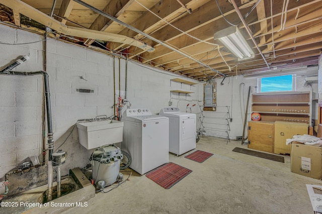 basement featuring separate washer and dryer, sink, and electric panel