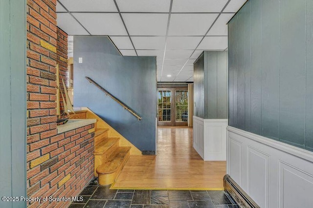 hall featuring a paneled ceiling and a baseboard radiator