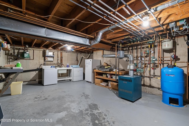 basement featuring sink, independent washer and dryer, and white fridge