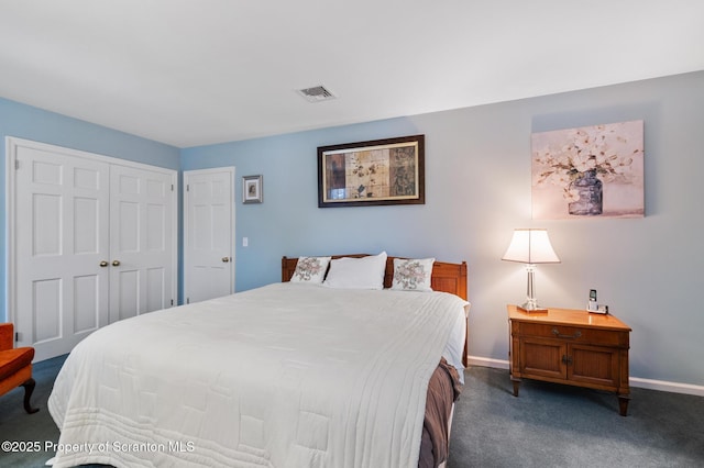 bedroom with dark carpet and a closet