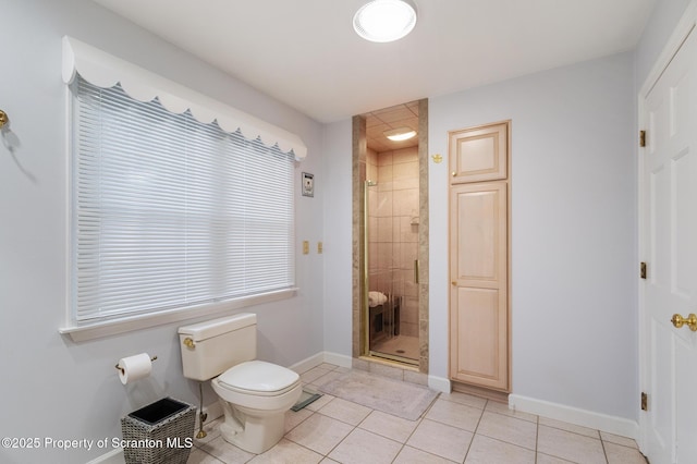 bathroom featuring tile patterned flooring, a shower with door, and toilet