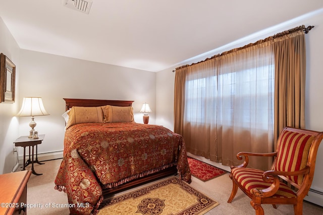 bedroom featuring a baseboard heating unit and light colored carpet