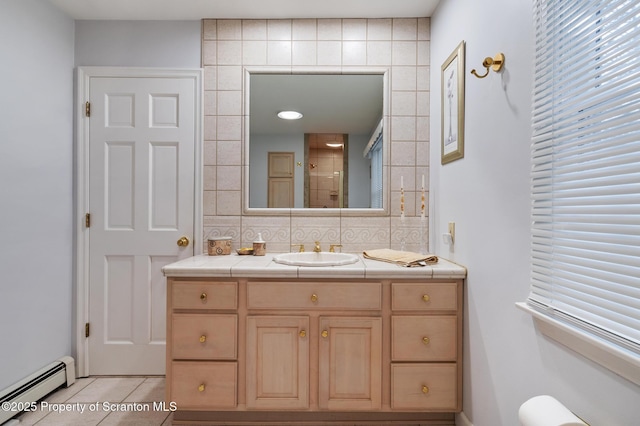 bathroom with tile patterned flooring, a baseboard heating unit, vanity, tasteful backsplash, and walk in shower