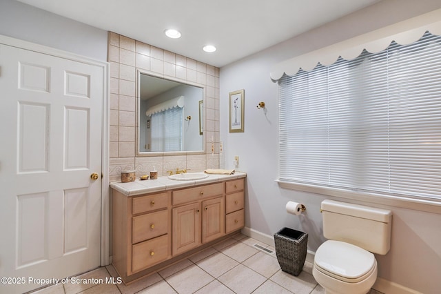 bathroom featuring tile patterned floors, toilet, vanity, and backsplash