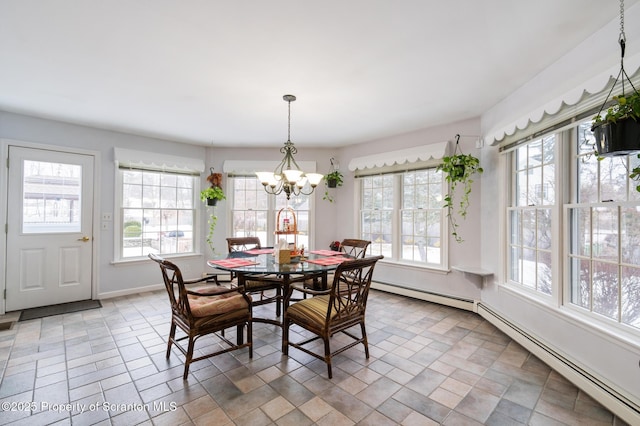 dining room with a baseboard heating unit, a wealth of natural light, and a notable chandelier