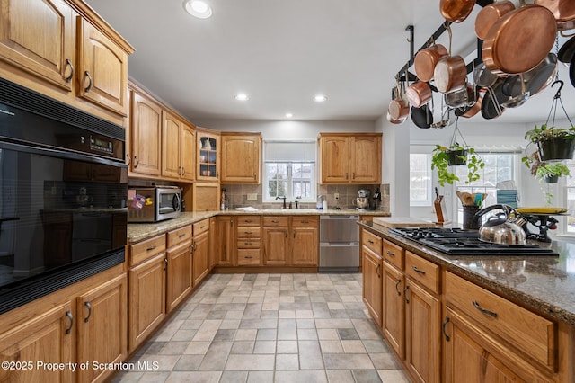 kitchen featuring tasteful backsplash, stainless steel appliances, and light stone countertops