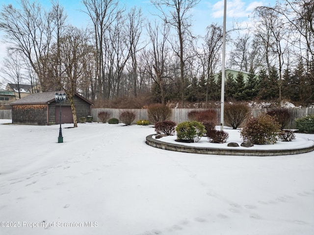 yard covered in snow featuring a garage and an outdoor structure