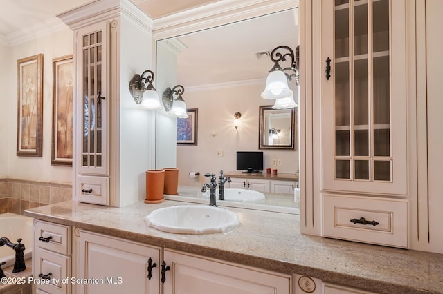 bathroom with vanity, crown molding, and a bathing tub