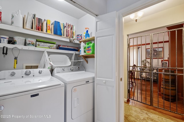 laundry room with independent washer and dryer and light wood-type flooring