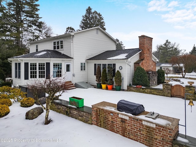 view of snow covered back of property