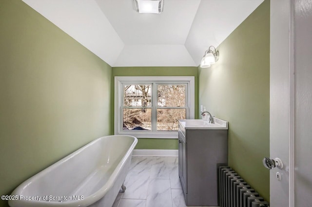 full bathroom featuring a freestanding tub, vanity, baseboards, marble finish floor, and radiator heating unit