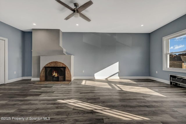 unfurnished living room with a fireplace with flush hearth, baseboards, and wood finished floors