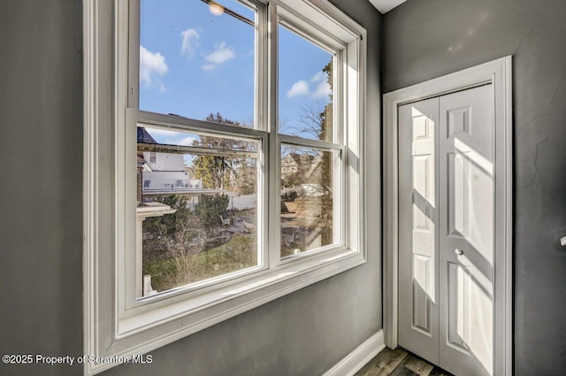 doorway to outside with wood finished floors and baseboards