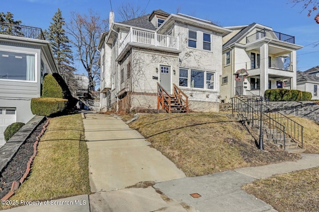 view of front of property with entry steps, a chimney, and a balcony