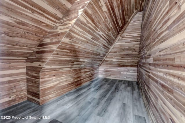 additional living space featuring dark wood-style floors, wood ceiling, and wooden walls